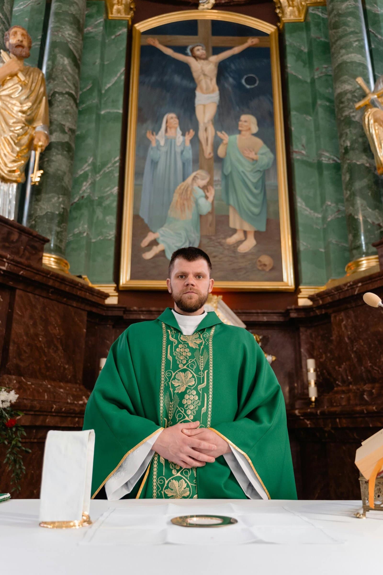 Supervision im Aargau (Praxis Liebesengel) 6 Priest in green vestment conducts religious ceremony at ornately decorated altar with crucifix.